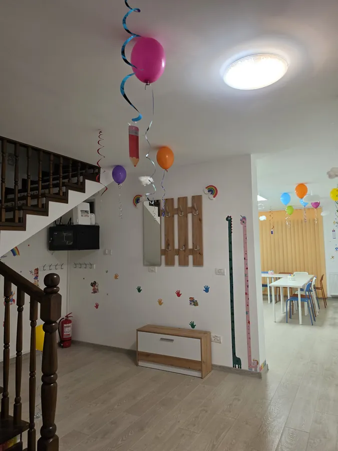 Holul de la intrare cu scara din lemn, decorat cu baloane la inaugurare