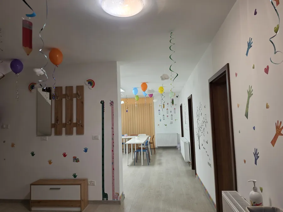Holul de acces către sălile de clasă, cu pereți decorați cu autocolante colorate